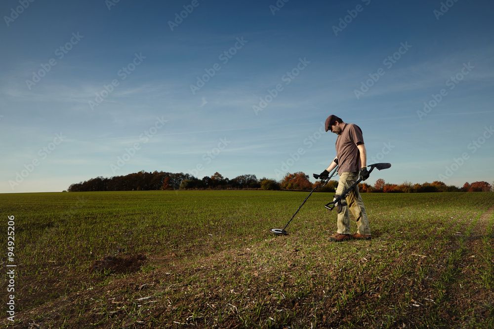 Exploring autumn field with metal detector - obrazy, fototapety, plakaty 