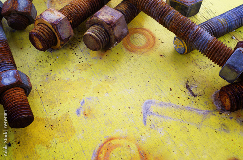 Closeup of rusty screw-nut on yellow wooden