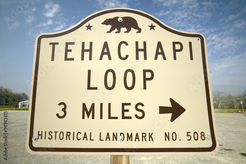 A monument sign from 1955 showing the Tehachapi Train Loop near Tehachapi California is the historic location of the Southern Pacific Railroad where freight trains gain 77 feet in elevation and show freight cars traveling in giant loop photo