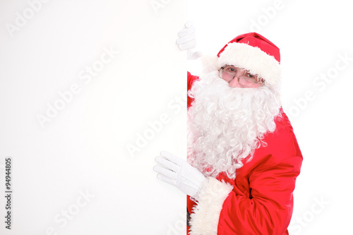 Kind Santa Claus pointing in white blank sign, isolated on white background