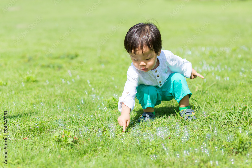 Little boy touch on the bubble at park Little boy touch on the bubble at park