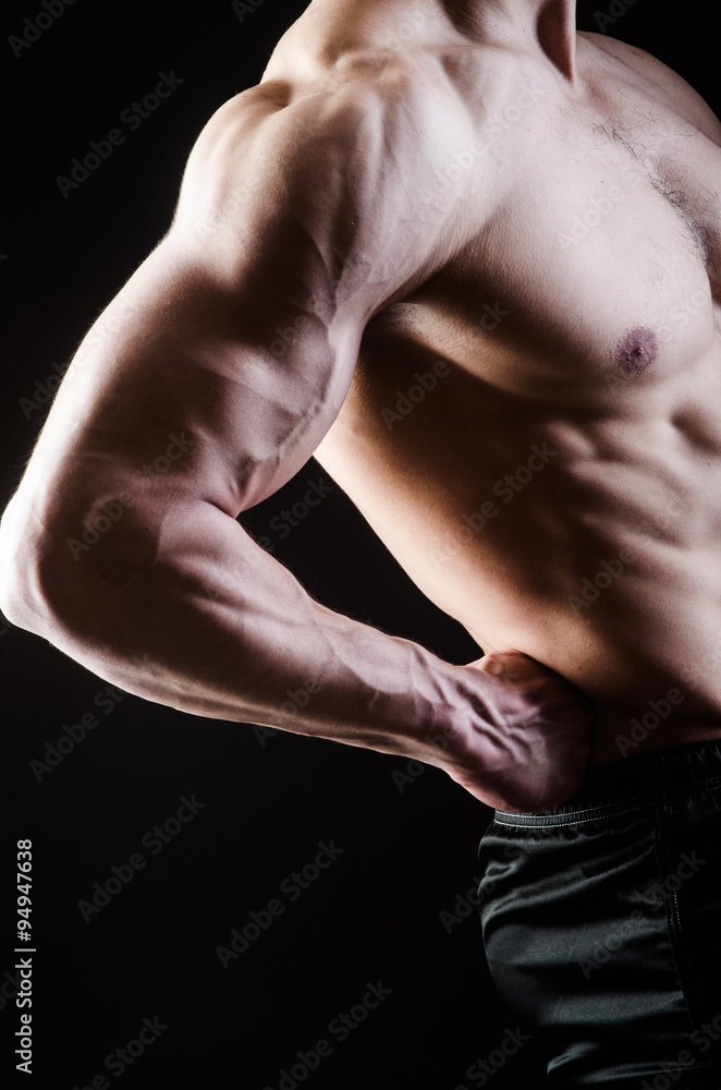 Muscular man posing in dark studio Muscular man posing in dark studio