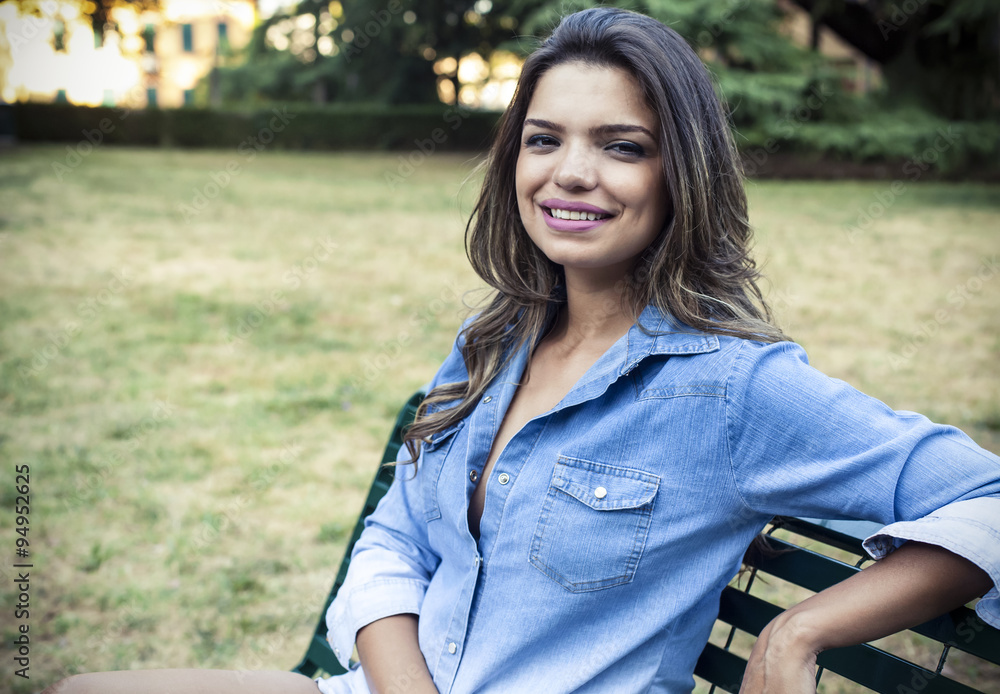 Beautiful girl relaxing outdoor on a bench in a park Beautiful girl relaxing outdoor on a bench in a park