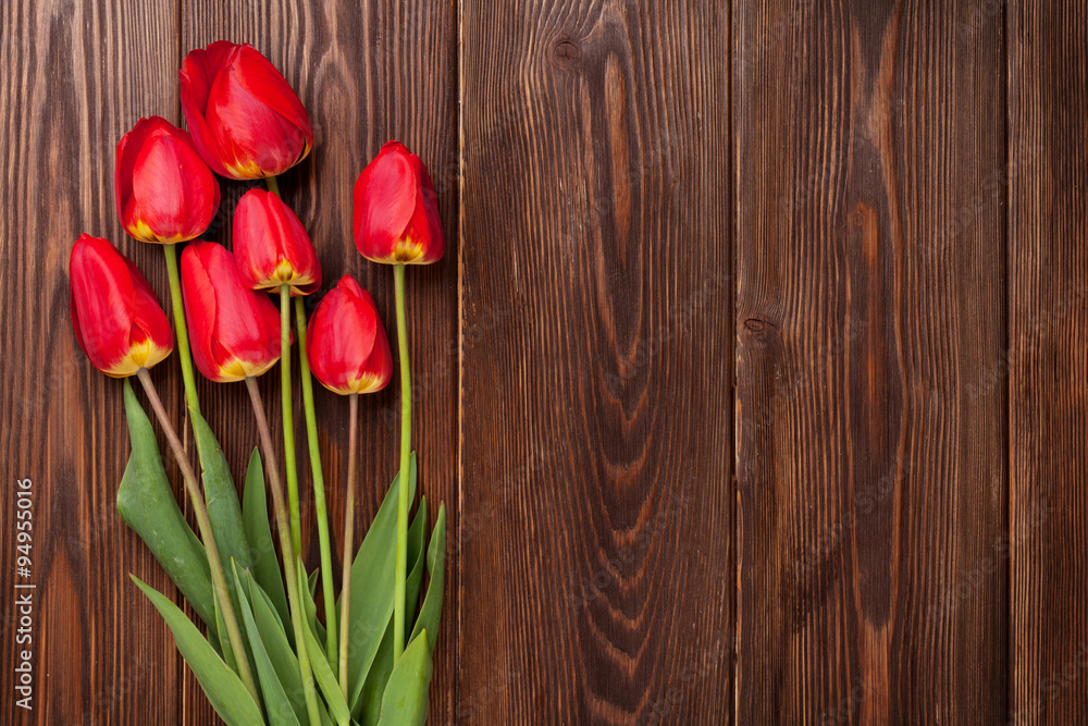 Red tulips bouquet over wood
