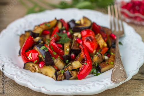 Salad of baked vegetables. Eggplant and bell peppers with pomegr photo