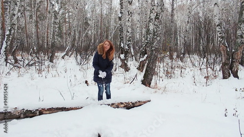 The girl iwalking in the winter woods with phone photo