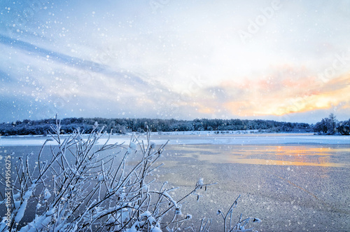 Winter landscape with lake and trees covered with frost