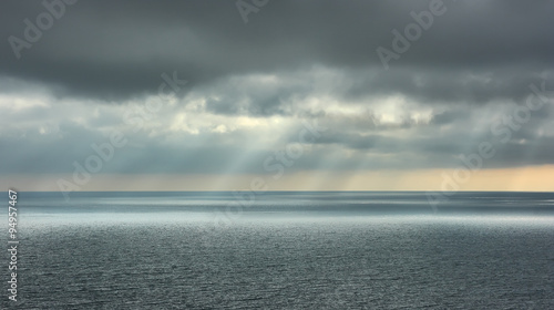 Beautiful seascape. Landscape with dramatic clouds over the sea and rays of sun. photo