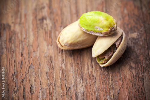 Pistachios with salt on wooden background