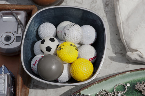 a bowl with old golf balls at a flea market in Lisbon, Portugal