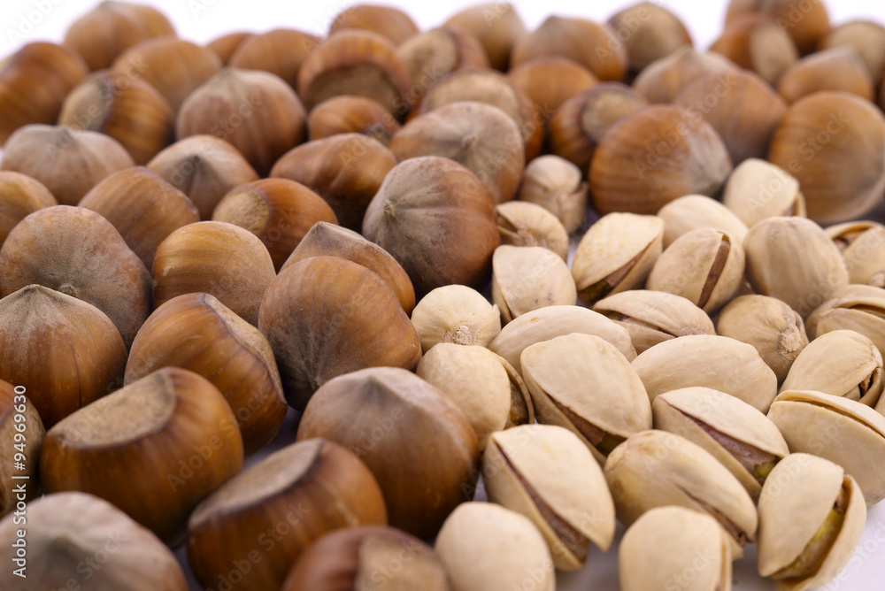 pistachios and hazelnuts on a white background pistachios and hazelnuts on a white background