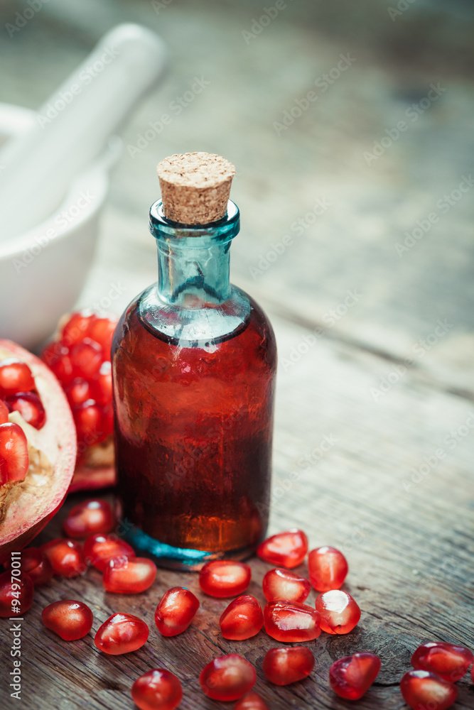 Pomegranate juice or tincture and garnet fruit with seeds on woo Pomegranate juice or tincture and garnet fruit with seeds on woo