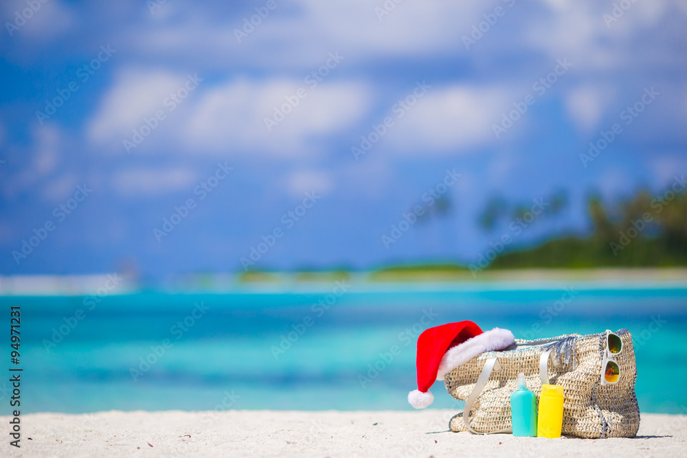 Beach accessories with Santa Hat on white tropical beach Beach accessories with Santa Hat on white tropical beach