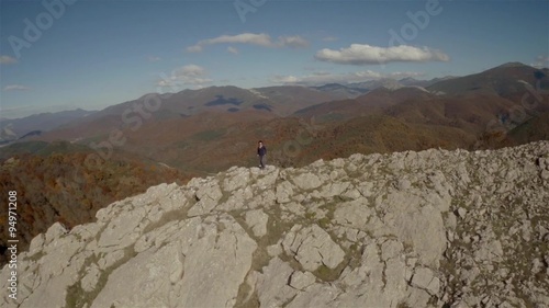Aerial shot of a woman in the top of a rock mountain