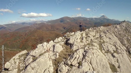 Aerial shot of a woman in the top of a rock mountain
