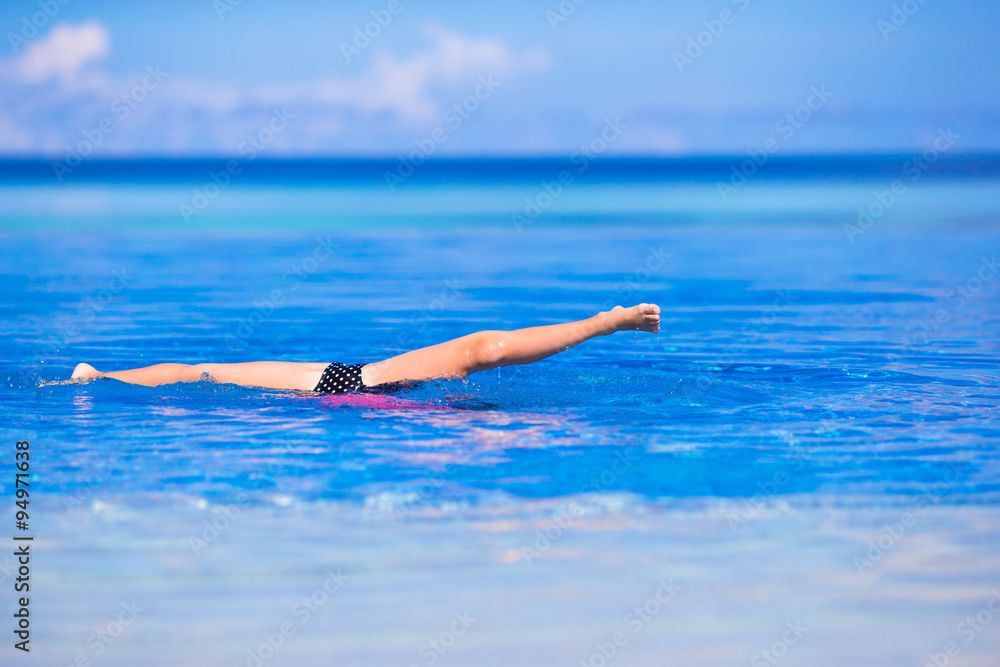 Little happy adorable girl in outdoor swimming pool