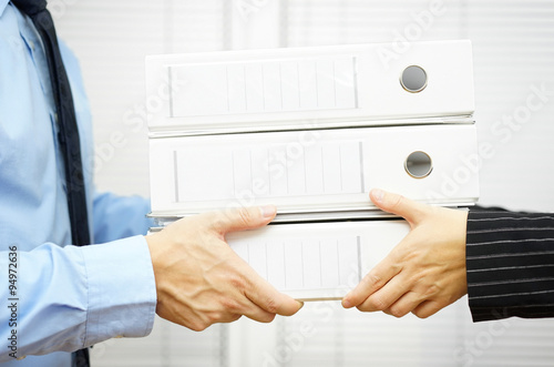 Photos Client is passing documentation in binders to his partner