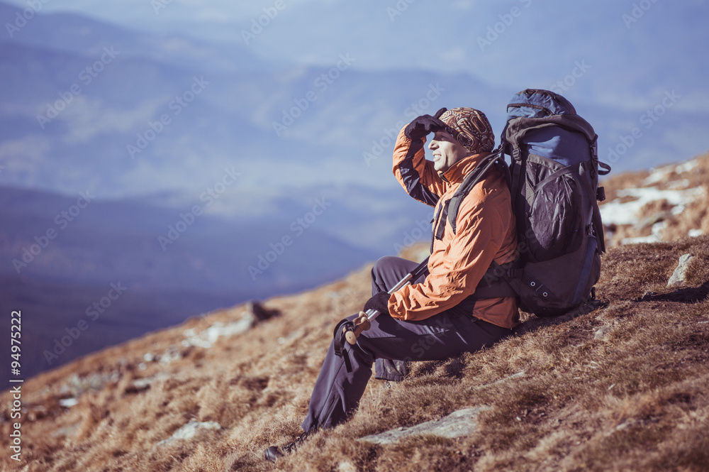 Man Traveler with Backpack hiking in Mountains with beautiful landscape
