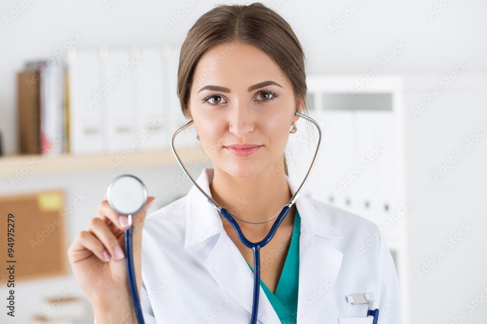 Portrait of beautiful female doctor holding stethoscope head Portrait of beautiful female doctor holding stethoscope head