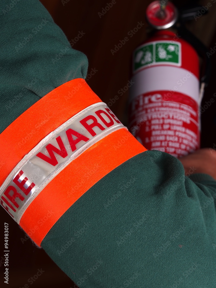 Fototapeta premium Fire warden with a reflective high visibility identification patch holding a fire extinguisher, Melbourne 2015
