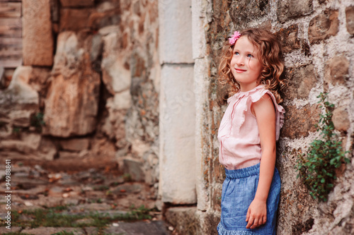 tourist child girl on the walk on streets of Piran, Slovenia in summer