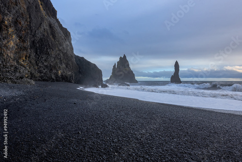 view of the black sand and rough sea at the beach of Vik in Iceland