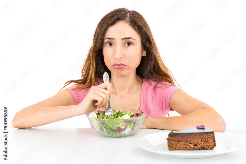Weight loss woman eating salad wishing for a piece of cake Weight loss woman eating salad wishing for a piece of cake