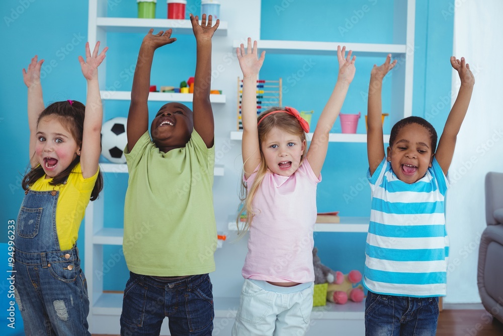 Fototapeta premium Happy kids with arms raised together