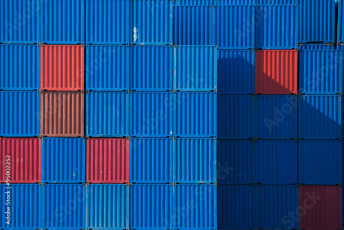 Full frame close up of stacked blue and red shipping containers in a port photo