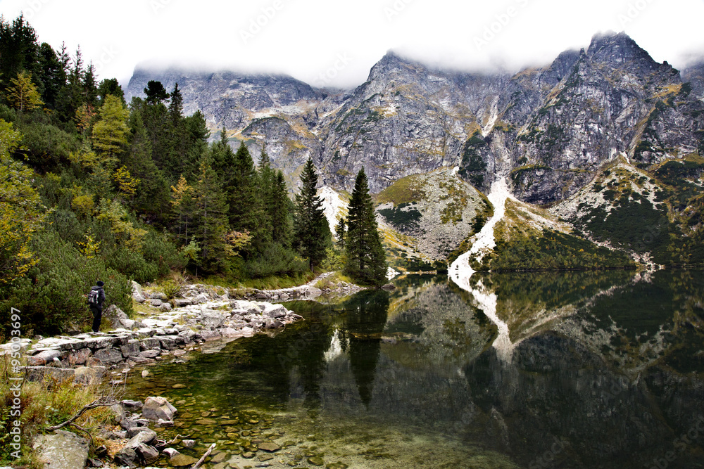 Beautiful scenery in the Tatra Mountains with hiker and reflections