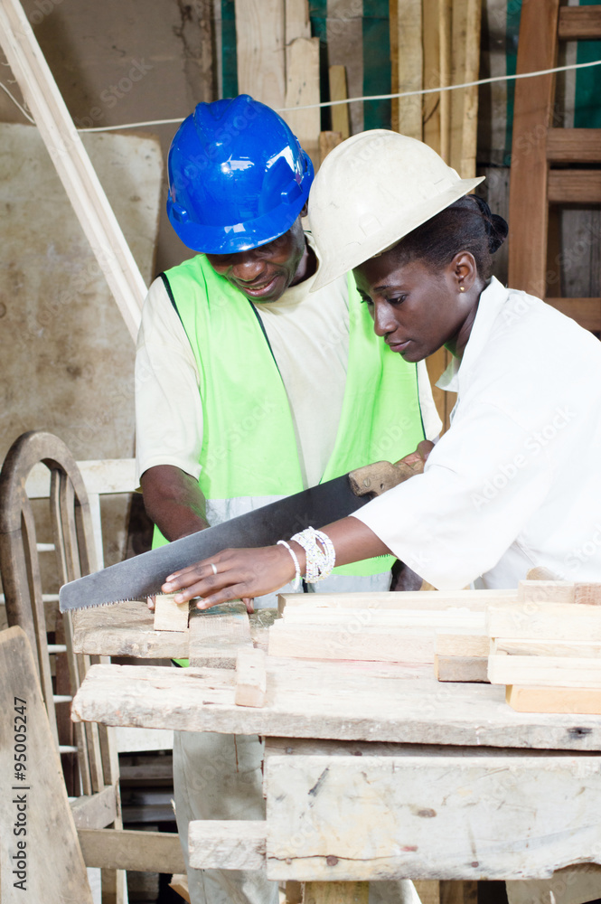 Young student learning to saw wood. Young student learning to saw wood.