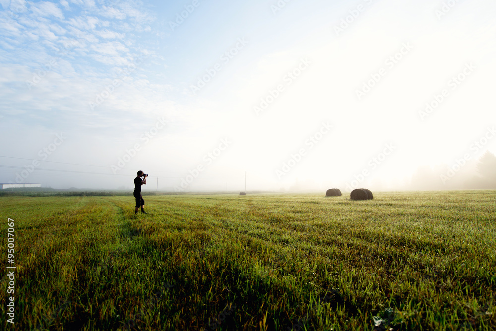 photographer in the fog taking a picture of the landscape photographer in the fog taking a picture of the landscape