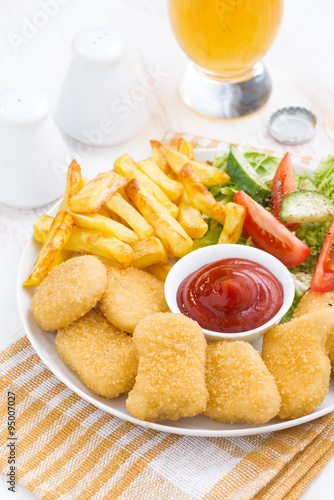 fast food - chicken nuggets, french fries and vegetable salad
