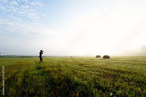 photographer in the fog taking a picture of the landscape © grthirteen