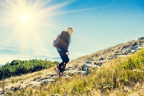 Woman hiker trekking in mountains.