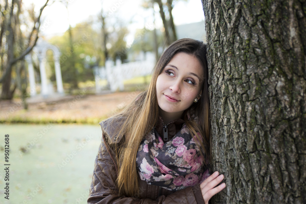 Portrait of beautiful young brunette girl in the park at fall. Portrait of beautiful young brunette girl in the park at fall.