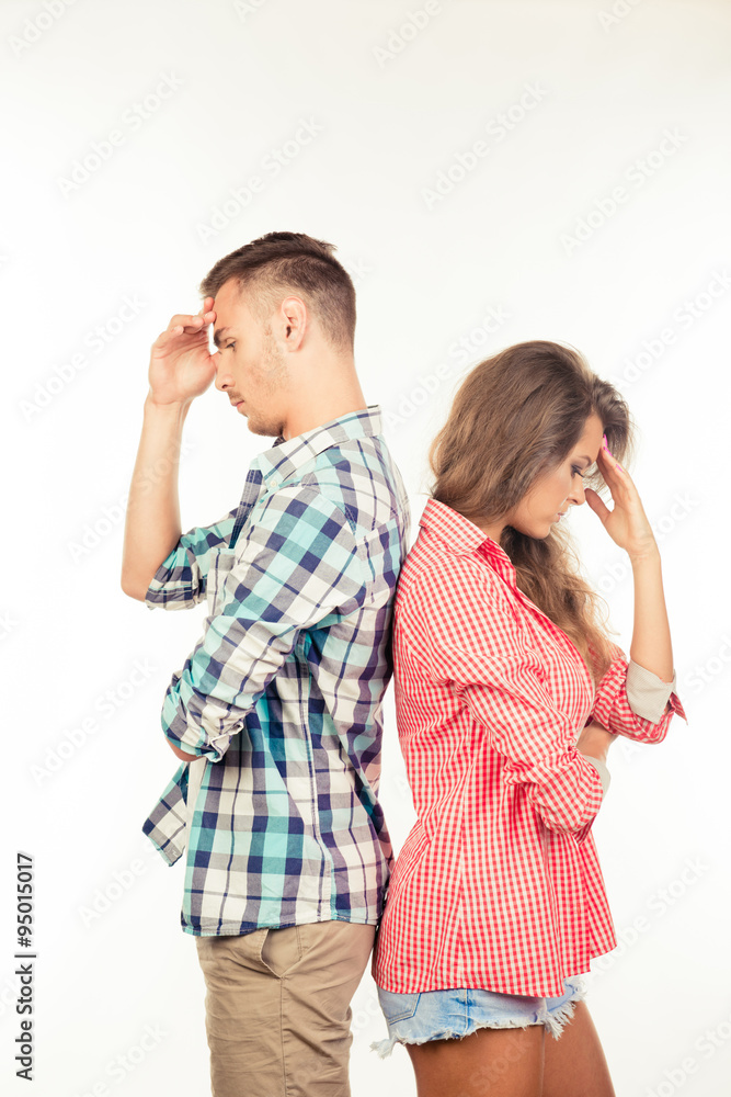 Young couple standing back to back ignoring each other Young couple standing back to back ignoring each other