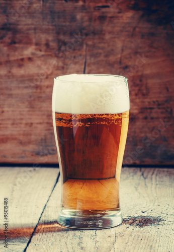 Canvas Print large glass of light beer with foam on the old wooden background