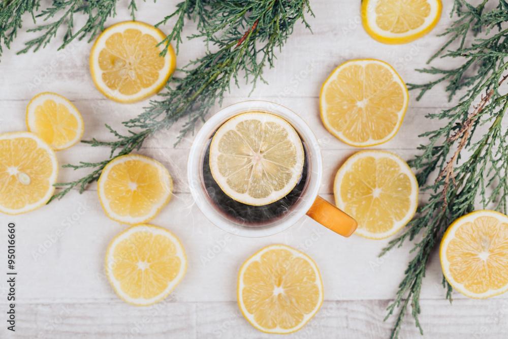 Close up shot of tea cup with lemon slices on white wooden table. Photographed from above. Close up shot of tea cup with lemon slices on white wooden table. Photographed from above.