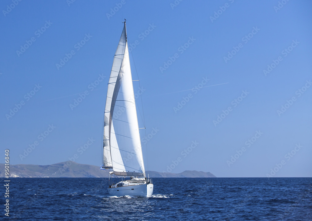 Sailing in the wind through the waves at the Aegean Sea. Yachting.