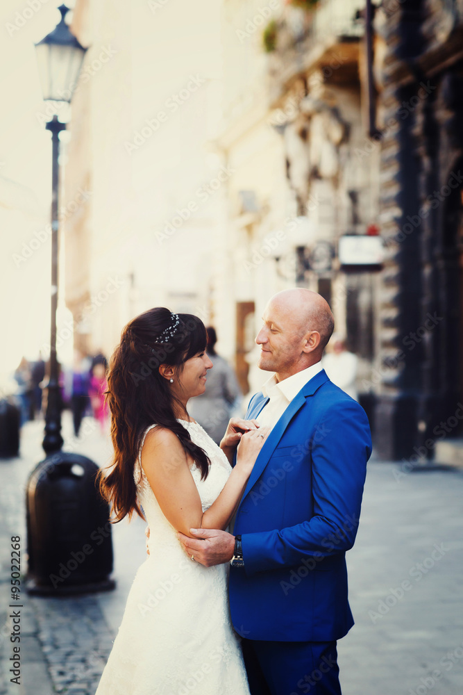 brunette bride hugging at the bald groom on the streets of the o brunette bride hugging at the bald groom on the streets of the o