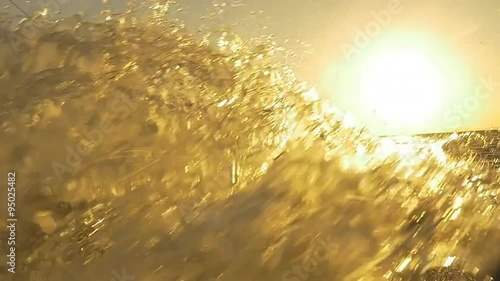SLOW MOTION: Kiteboarder splashing water into the camera at sunset