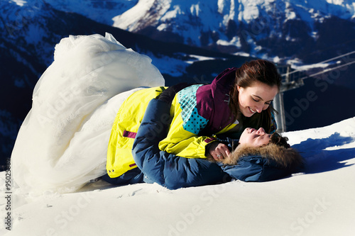 bride and groom in love luing on snow  on the background of the photo