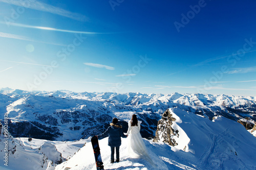bride and groom in love walking on the background of the Alps Co