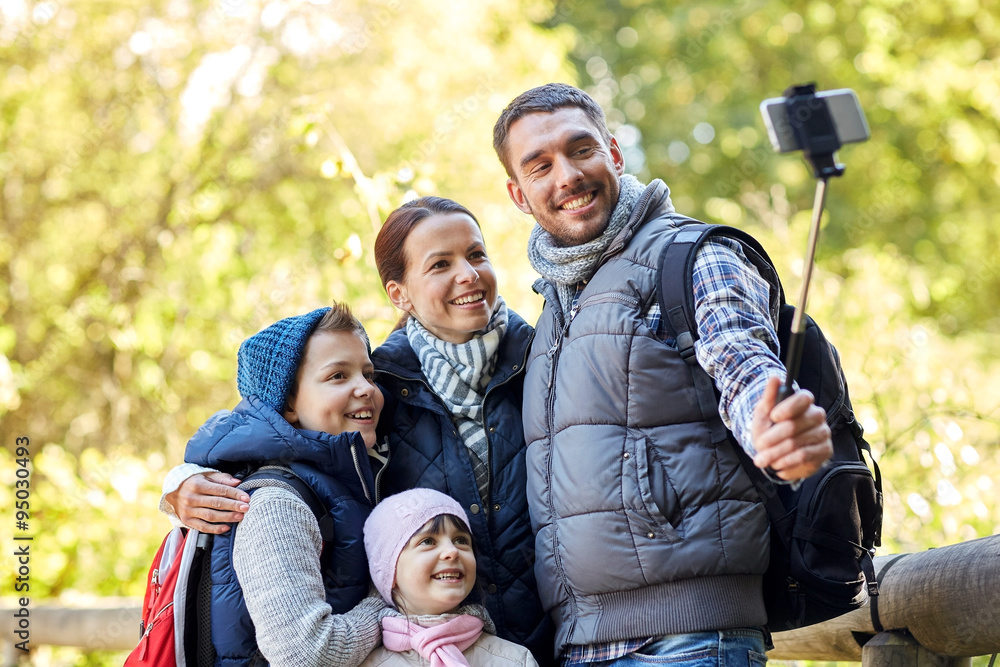 happy family with smartphone selfie stick in woods happy family with smartphone selfie stick in woods