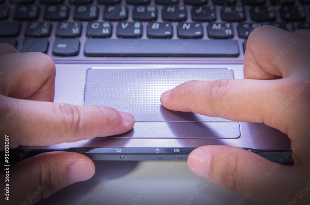 hands typing on a laptop trackpad hands typing on a laptop trackpad