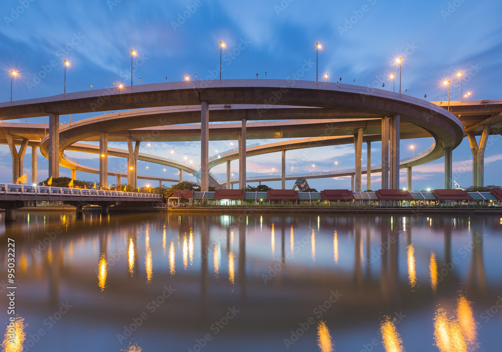Highway interchange curved river front view during twilight Highway interchange curved river front view during twilight