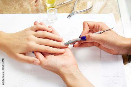 Tablou pe pânză Cuticle pusher tool in nails salon woman hands