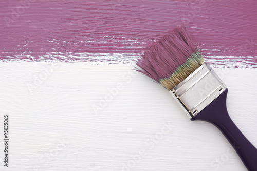 Stripe of plum paint with a paintbrush on white