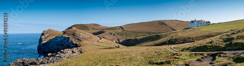 Panoramic view with a farmhouse and the coastline near Port Quin in north Cornwall.